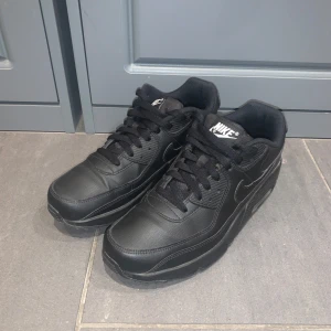 Helt nya Svarta Nike Air Max  - Säljer ett par svarta Nike Air Max i skinn. De är i mycket bra skick använd 2 gånger och har en klassisk design med snörning och Nike-logga på sidan. Perfekta för både vardag och träning. Skorna har en bekväm passform och den ikoniska Air Max-sulan för extra komfort.