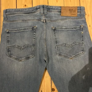 Blå Rocco jeans från Replay -  Säljer ett par snygga blå jeans från Replay i modellen Rocco. De har en bekväm passform och är perfekta för vardagsbruk. Jeansen har klassiska bakfickor och en stilren design. Perfekta för både höst och vår!
