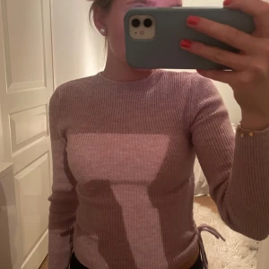 Ljusrosa ribbad tröja - Säljer en superfin ljusrosa/lila ribbad tröja med långa ärmar. Den har en snygg snörning på sidan som ger en cool detalj. Tröjan är i bra skick och passar perfekt till höst och vår! 💖