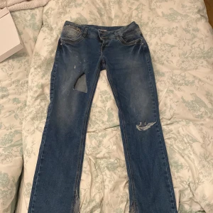 lågmidjade jeans från LTB med hål  - Säljer ett par blå jeans från LTB med slitna detaljer och hål på benen. De har en klassisk femficksdesign och är väldigt skönt, har bara haft dom på mig 1 gång