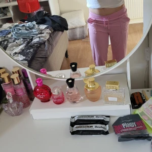 Rosa juicy couture byxor - Säljer ett par Rosa juicy couture byxor. De har en loose passform och är perfekta för en chill dag hemma eller för att ha somnvardags byxor.. Byxorna har praktiska fickor med knappar bak och en elastisk midja för extra komfort. Perfekta för mysiga hemmakvällar eller en avslappnad dag ute.