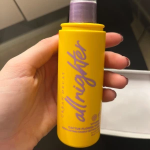Urban Decay All Nighter Face Mist - Säljer en Urban Decay All Nighter Face Mist i en cool gul flaska med lila text. Den innehåller vitamin C och kaktusblomvatten för att hålla sminket fräscht hela dagen. Perfekt för att sätta sminket och ge en uppfriskande känsla. Flaskan är smidig och lätt att ta med sig. Ca 50% kvar 