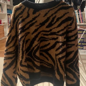 Zebramönstrad stickad tröja - Säljer en supercool zebramönstrad stickad tröja i svart och beige. Perfekt för höst och vinter med sin mysiga och varma känsla. Tröjan har långa ärmar och en normal passform. Perfekt för att sticka ut i mängden! 🖤