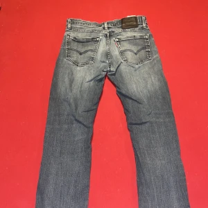 Blå Levis 511 - Ett par Levis i storlek W31 L32, men krympt lite så passar bättre W 28 L 32. Modell 511. Skicket är rätt bra förutom litet hål nedanför gylfen, se bild 4. Förg mörkblå och ljusblå. Hör av dig vid fler frågor eller bilder.