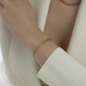 Elegant guldarmband och halsband från Mockberg - Säljer ett stilrent set med ett guldarmband och matchande halsband. Båda smyckena har en vacker flätad design som ger en lyxig känsla. Perfekt för både vardag och festliga tillfällen. Armbandet och halsbandet har en säker låsning som gör att de sitter på plats hela dagen.