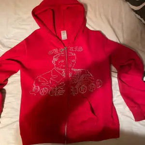 Säljer en cool röd hoodie med dragkedja och glittrig design på framsidan. Perfekt för att sticka ut i mängden! Den har en bekväm passform och är perfekt för både vardag och fest. Huvan ger extra mysfaktor. Hör av dig vid intresse! ✨