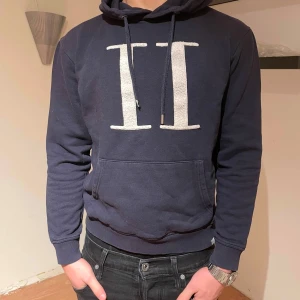 Les delux tröja marinblå - Säljer en snygg mörkblå hoodie med en stor vit logga på framsidan. Den har en klassisk passform med långa ärmar och en bekväm huva. Perfekt för en avslappnad stil eller för att hålla sig varm under kyliga dagar.