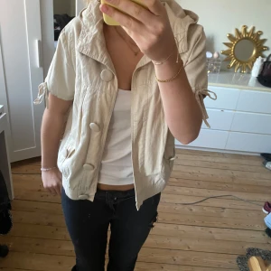 Beige jacka från Pretty in the City - Säljer en söt beige jacka från Fairy in the City. Den har korta ärmar med knytband och stora knappar framtill. Perfekt för vår, höst och sommar! 🧥✨