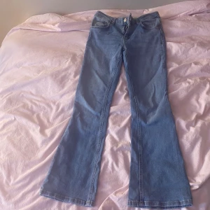 Blå bootcut jeans - Säljer ett par snygga blå low waist bootcut jeans