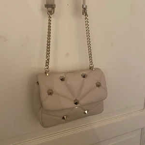 Beige väska Zara - Snygg väska från Zara med guldiga nitar. Helt oanvänd men utan lapp och helt utan skador eller defekter💕