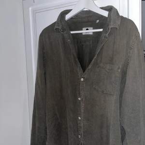 Säljer en snygg grön overshirt från NN07 i storlek L liten i storleken . Skjortan har en avslappnad passform med långa ärmar och knappar framtill. Perfekt för lager-på-lager.