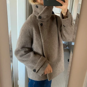 Beige ullkappa arket - Den är snygg, varm och i gott skick. Lite fluffigare och ”hårigare” än vad det ser ut på bilderna! Storlek 34. Använd en säsong köpt på arket! 