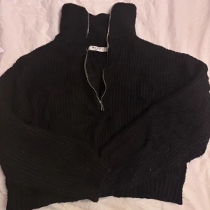 Svart ribbad tröja med dragkedja från NA-KD - Säljer en svart ribbad tröja från NA-KD i mycket bra skick. Den har en dragkedja framtill och är perfekt för höst och vinter. Tröjan är långärmad och supermysig att ha på sig. Perfekt för en chill dag eller en mysig kväll hemma. 🖤