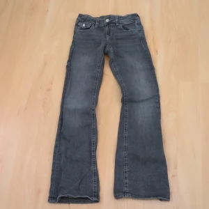 Grå jeans med broderade bakfickor - Säljer ett par grå jeans från Gina Tricots barnavdelning Gina Young. De har en broderad detalj på bakfickorna. 