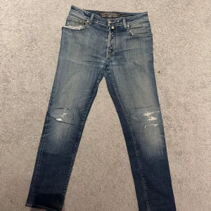 Jacob Cohen jeans - Hej, jag säljer ett par jätte fina Jacob Cohen jeans med slitninga som är i storlek 34!. De är i fint skick! Slitagen är handgjorda och var så när jag köpte byxorna! Väldigt sköna och schyssta jeans.  Finns tecken på användning och slitage på både utsidan och insidan! Hör av er vid minsta lilla. Öppen för byten!