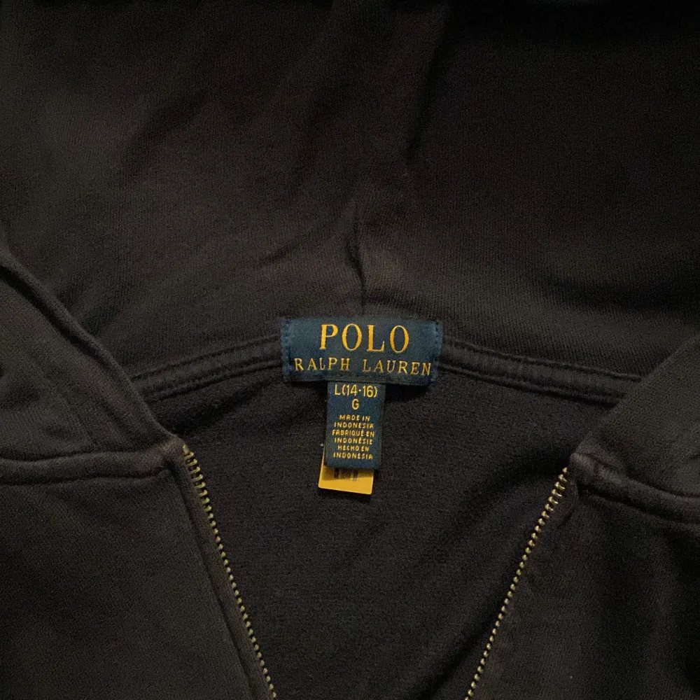 Säljer en stilren mörkblå zip hoodie från Ralph Lauren i storlek L i barn. Den har en dragkedja framtill och en liten broderad logga på bröstet. Perfekt för både höst och vinter, och passar till alla tillfällen. Superbekväm och i bra skick! Pris kan diskuteras.. Tröjor & Koftor.