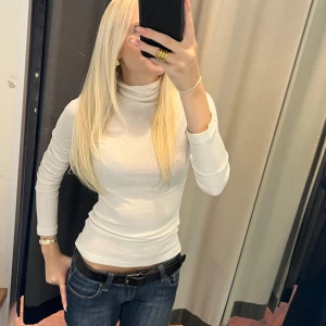 Vit polotröja - Säljer en stilren och bekväm vit polotröja i ullblandning, 40% ull❄️ Ny med prislapp kvar!! Perfekt för både vardag och fest. Tröjan har en tight passform och långa ärmar, vilket gör den idealisk för kyligare dagar. Den är lätt att matcha med både jeans och kostymbyxor. Ett måste i garderoben för en klassisk look!