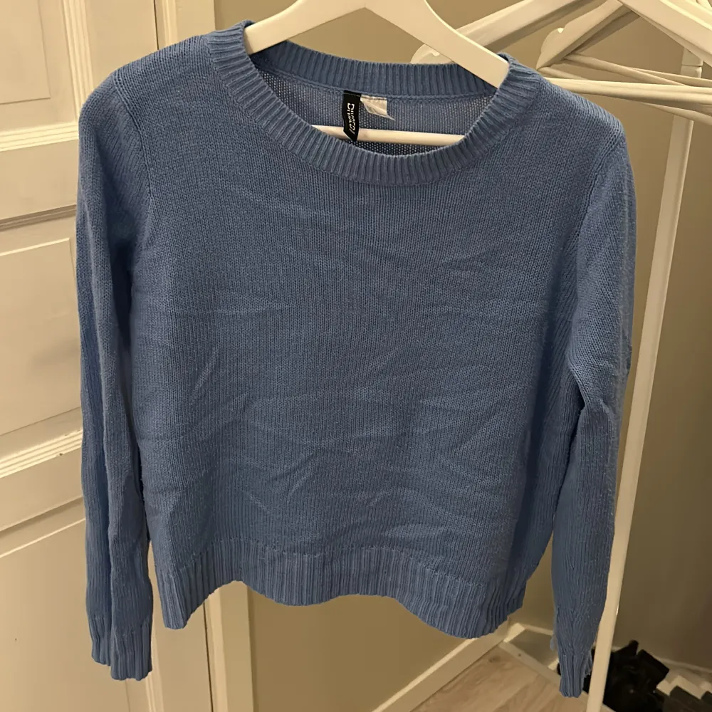 Säljer en superfin blå stickad tröja från H&M Divided. Den har en klassisk rund halsringning och långa ärmar. Perfekt för både höst och vår! Tröjan är i bra skick och passar perfekt för en casual look. 🦋. Neuletakit & Villapaidat.
