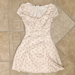 blommig klänning - Kort vit klänning med småblommigt mönster i stl xs. Klänningen är endast provad, aldrig använd. Klicka gärna på köp nu och meddela för eventuella frågor. :)