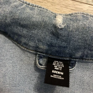 Ljusblå jeansjacka från &Denim - Säljer en snygg ljusblå jeansjacka från &Denim. Jackan har en klassisk design med knappar framtill och två bröstfickor. Perfekt för vår och sommar! Den är i bra skick och passar till de flesta outfits. Perfekt för en casual look! 💙