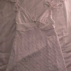 Vit klänning från H&M Divided - Säljer en söt vit klänning från H&M Divided i storlek S💕. Klänningen har ett fint broderat mönster och smala axelband som knyts. Klänningens längd är typ ovanför knäna. Aldrig använt! 
