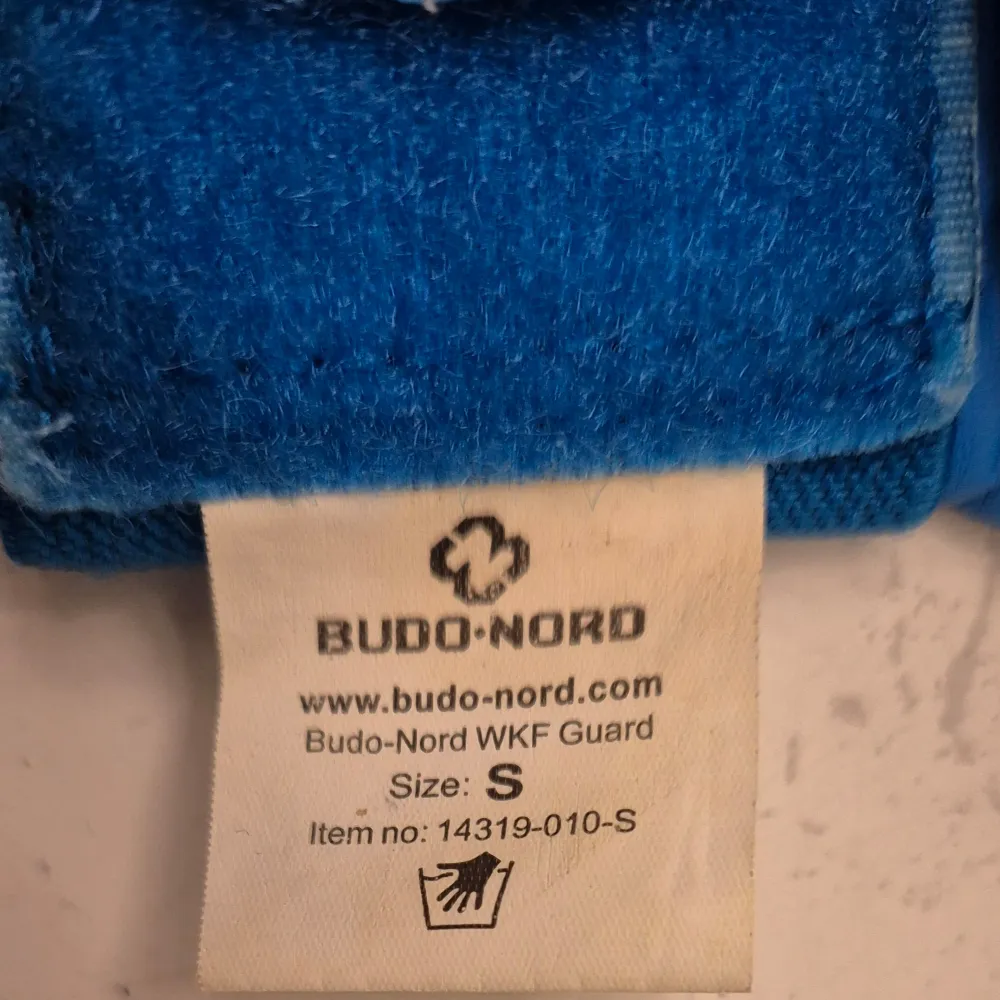 Säljer ett par blå kampsportshandskar från Budo-Nord i storlek S. De är WKF-godkända och har en justerbar kardborrestängning för perfekt passform. Perfekta för träning och tävling. Använda men i bra skick. Passa på att köpa dessa kvalitetsprodukter för din kampsportsträning! 🥊. Övrigt.