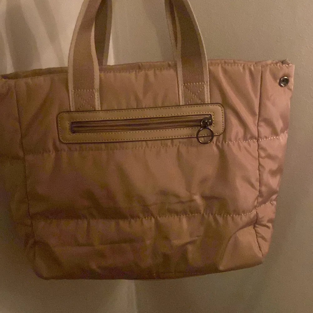 Säljer en superfin beige väska från Chloé. Den har två  handtag och en praktisk dragkedja på baksidan. Insidan är rymlig med flera fack för bra organisering. Perfekt för både vardag och fest! 👜✨💖💖. Väskor.