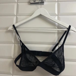 Svart spets-bh med mönster från SHEIN. Storlek: L - Snygg svart bh i spets med ett diskret geometriskt mönster. Justerbara axelband och hakknäppning bak för perfekt passform. Perfekt för att lägga till en touch av elegans i din garderob.aldrig använd. Säljer för 80 kronor.✨