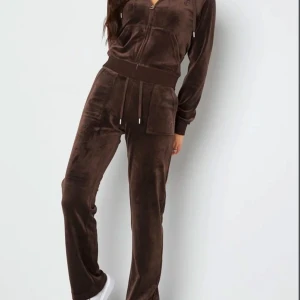 Juicy couture set - brunt - Säljer mitt bruna juicy set då den tyvärr inte kommer till användning. Settet är köpt på NK som en present och är i väldigt bra skick. Dock är dessa byxor uppsydda då jag är väldigt kort då jag ej rekommenderar en person med längre ben att köpa den. Tröjan är i S medans byxorna i XS. Kan skicka fler bilder om det önskas.