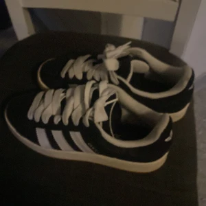 Svarta Adidas Campus sneakers - Snygga svarta Adidas campus sneakers som knappt är använda säljer eftersom jag inte gillar stilen och det var ett spontan köp, skick 9/10. Dock väldigt sköna, kan såklart tvätta skorna innan de skickas iväg!!