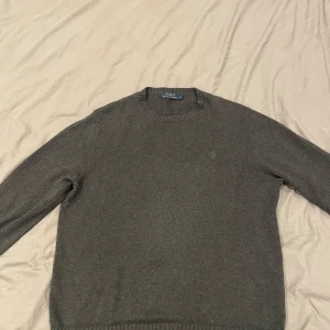 Grå stickad Ralph Lauren sweatshirt  - Storlek L men funkar M med. Nypris 2395kr. Skick 9/10 inget tecken på användning. Skickar samma dag. Pris kan diskuteras.