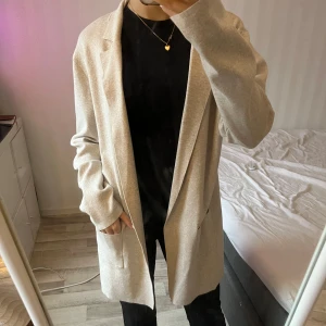 Beige kofta från Alice Bizous - Säljer en stilren beige kofta från Alice Bizous i storlek M. Koftanhar en klassisk design med långa ärmar och två fickor framtill. Perfekt för en elegant look. Köpte den väldigt dyrt och den är nästintill helt oanvänd