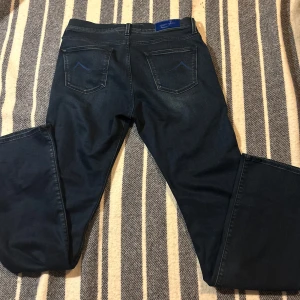 Mörkblå jeansbyxor med broderade detaljer - Jacob Cohen jeans 399 kr. Jag säljer dessa Jacob cohen jeans på grund av att det var alldeles för långa i benen men det är W31 och finns inga defekter på jeansen