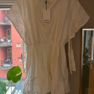 Vit klänning från Rodebjer - Säljer en vacker vit klänning från Rodebjer med broderade detaljer. Klänningen har en luftig passform och korta ärmar, perfekt för varma dagar. Ett stilrent val för sommarens alla tillfällen. Även perfekt som studentklänning ! Det är en storlek XS men skulle även säga att den passar en S. Ny med prislapp