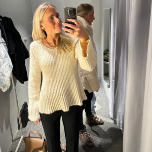 Beige stickad tröja - Säljer en mysig beige stickad tröja med v-ringning. Tröjan har långa ärmar och en lätt utsvängd nederkant som ger en fin passform. Perfekt för kyligare dagar.