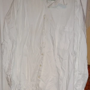 Vit skjorta från LL - Klassisk vit skjorta från LEE med långärmad design och knappar framtill. Perfekt för en stilren look. Skjortan har en bröstficka och är tillverkad i ett lätt och bekvämt material.