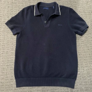 Gant Pikétröja - Mörkblå - Snygg mörkblå pikétröja från Gant. Tröjan har en diskret logga på bröstet och vita detaljer på kragen. Perfekt för en snygg outfit! Nypris tror jag var runt 1200, knappt använt men liten liten fläck på magen men går nog att får bort enkelt! Skriv vid frågor eller funderingar!