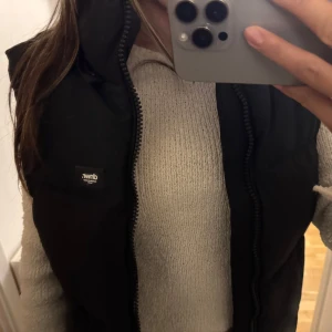 Svart dunväst från Zara - Snygg svart dunväst från Zara med dragkedja framtill. Perfekt för lager-på-lager under kyligare dagar. Västen har en stilren design och är lätt att matcha med olika outfits.