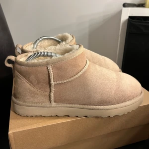 Ugg ultra mini, färgen sand  - Säljer mina mysiga ugg i färgen sand, storlek 39. Köpta för ca 4 månader sen på footlocker men kommer ej till användning då jag fått ett par nya, nypris 1900 kvitto medföljer!