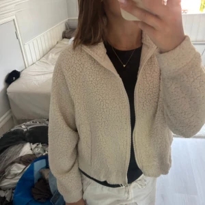 Beige teddyjacka från BikBok - Säljer en supermysig vit teddyjacka från BikBok i storlek XS. Jackan har en dragkedja framtill och är perfekt för kyliga höst- och vinterdagar. Den är långärmad och gjord i ett mjukt teddy-material som håller dig varm och bekväm. Super fint skick 