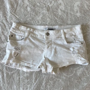 Vita zara shorts - Säljer vita zara shorts med tre knappar. Använt få gånger. Med små ditaljer på framsidan och baksidan
