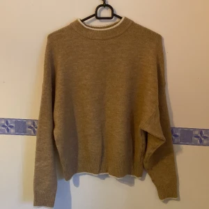 Stickad tröja i nyskick! - Superfin stickad tröja i beige med vita detaljer kring krage och muddar. Typ oanvänd så som ny! Storlek s dam 
