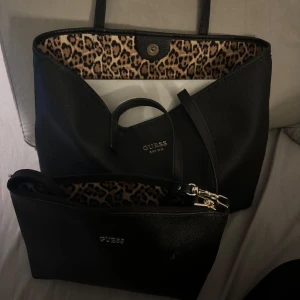 Två väskor från guss - Två stycken guss väskor som kommer tillsammans den lilla kan man knäppa in i den stora så de blir som ett fack i väskan. Endast använt den stora fåtal gånger den lilla är oanvänd. Leopard mönster inuti🐆🐆🐆🐆
