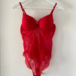 Röd spetsbody  - Röd body i spets med pushup-bh från H&M. Den har fina och väl gjorda spetsdetaljer. Endast använd en gång.