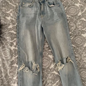 Ljusa jeans med slitningar - Säljer ett par ljusa jeans med hål. Modellen har raka ben och hög midja och de är i storlek 36. Fint skick och längden är bra på mig som är 167/168cm!