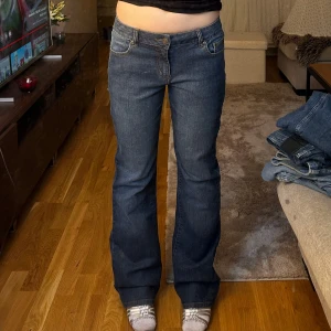 Blå bootcut jeans - Säljer ett par snygga blå bootcut jeans. De är lågmidjade och har en klassisk femficksdesign med knappar och dragkedja. Jättebra skick💕 