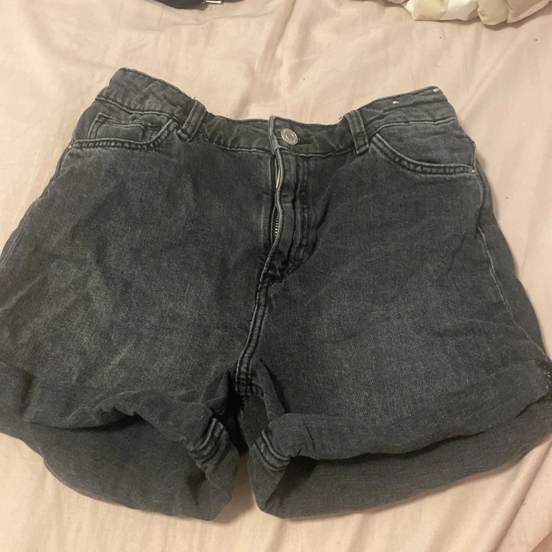 Ett par mörkgråa jeans shorts från H&M