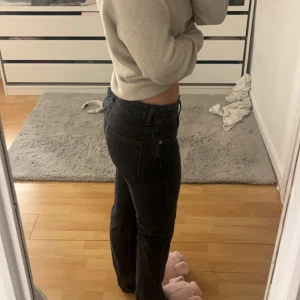 Svarta jeansbyxor - Snygga svarta jeansbyxor med låg midja och en klassisk straight passform. Perfekta för en avslappnad stil. De har en enkel design med fem fickor och knappgylf.