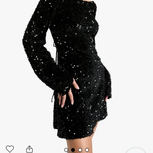 Svart paljettklänning från PrettyLittleThing - Snygg svart klänning från boohoo täckt med glittrande paljetter. Den har en öppen rygg med knytband och långa ärmar. Perfekt för en kväll ute! Passar perfekt till nyår😊den är splittrans ny och helt orörd. Om du är snabb kan du få den fö billig peng😍ops! Har även en lika dan i storlek M! Skriv om ni är intresserade av den 