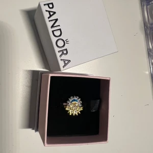 Ring med sol- och måndesign - Unik ring från Pandora med en vacker sol- och måndesign. Ringen har detaljer i guld och silver samt gnistrande stenar i blått och klart. Perfekt för att lägga till en touch av elegans och mystik till din stil.